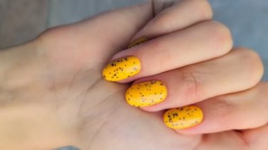 Kadın eli ve modaya uygun sarı manikürlü dikey video