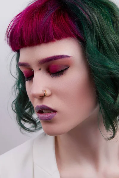 Beautiful woman with purple green professional colored hair. Bright eyes and lips makeup