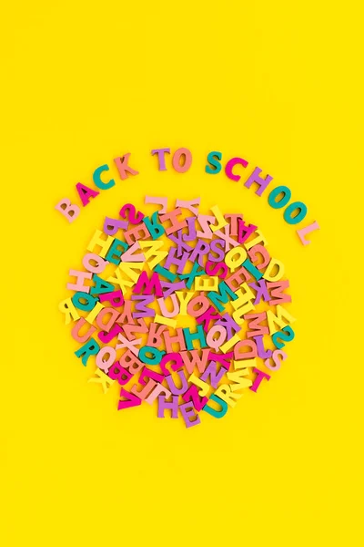 Flat lay top view text back to school on yellow background. — Stock Photo, Image