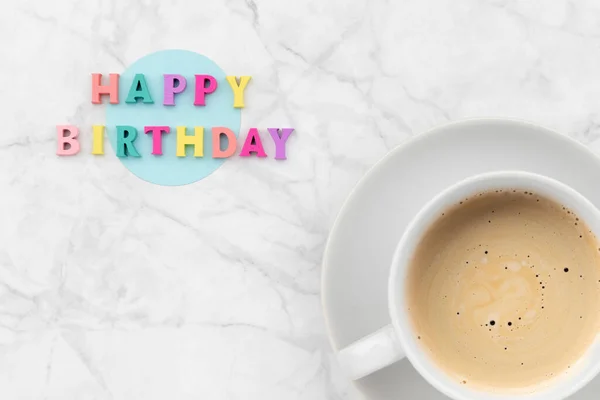 Texto de feliz aniversário de letras coloridas de madeira com xícara de café — Fotografia de Stock