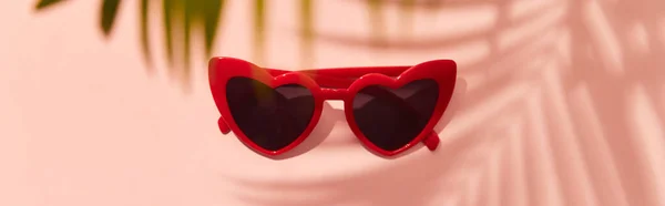 Gafas de sol rojas en forma de corazón sobre fondo rosa —  Fotos de Stock