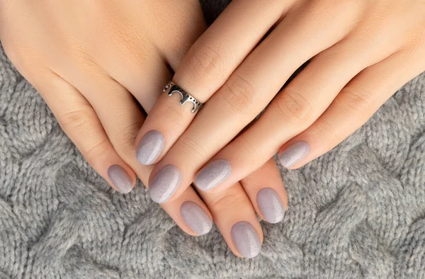 Schöne Frauenhände mit trendigem Nageldesign auf grauem Strickhintergrund — Stockfoto