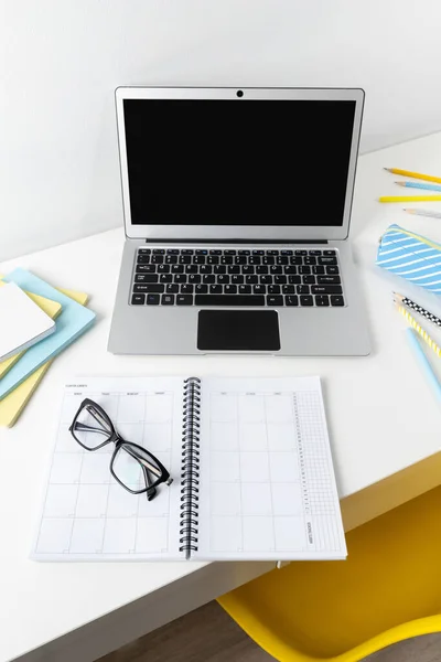 Laptop med blank skärm, glasögon och brevpapper på vitt modernt bord — Stockfoto
