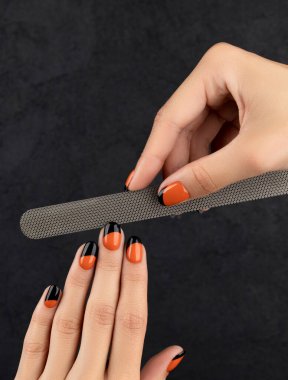 Manikürlü kadınlar siyah arka planı devreder.