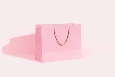Pembe arka planda kağıt alışveriş torbası. Alışveriş teslimatı konsepti