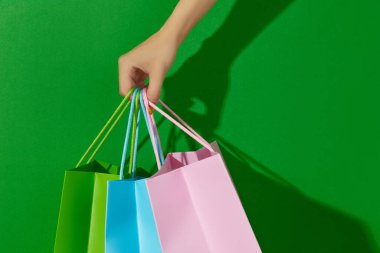 Yeşil arka planda alışveriş torbaları tutan kadınlar. Alışveriş satış konsepti
