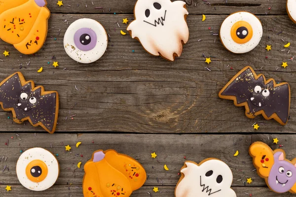 Leckere, zu Halloween selbst gebackene Plätzchen in verschiedenen Formen auf altem Holztisch — Stockfoto