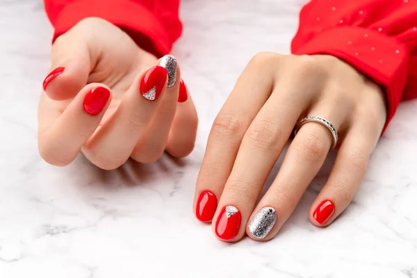 Красивые ухоженные женские руки с рождественским дизайном ногтей на мраморном фоне — стоковое фото