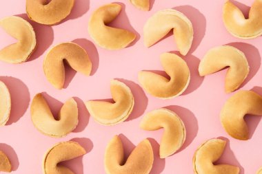 Pembe arka planda, uzun gölgeli fal kurabiyeleri olan desen