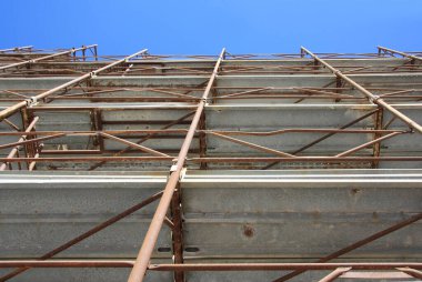 Çelik kiriş yapısı, bina mavi gökyüzü ile inşa ediliyor.