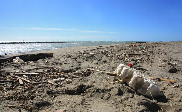 Pollution of the beach. Plastic bottles and other waste, with sea background