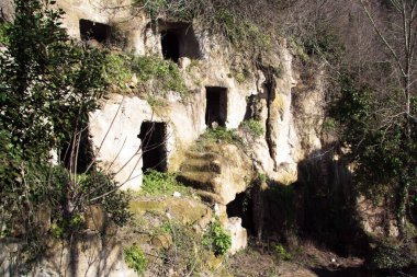 Dağda kış sabahı, antik mağaralar, kayalara oyulmuş birden fazla kapı.