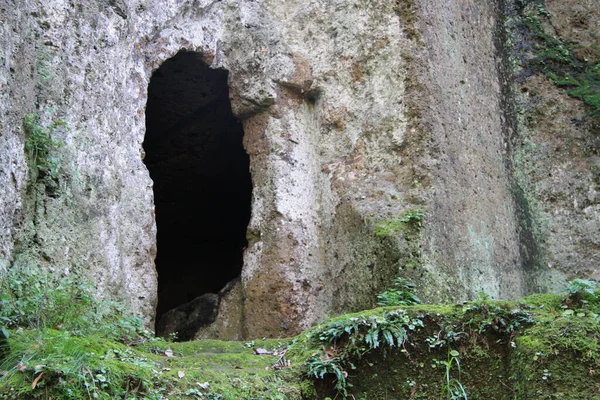 Etrurya mezarlığının detayları. Yeşil arazide ve kayalarda antik mezarlar.