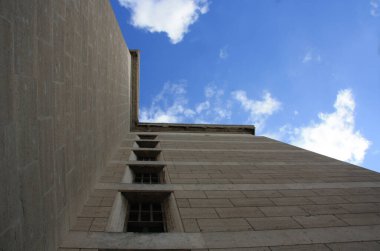 Pencereleri ve bulutlu gökyüzü olan antik bir bina. Eski kilisenin aşağısından manzara.