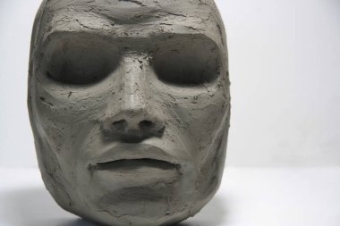 Islak kilin yüzü. Gözleri olmayan baş heykeli ve nazik özellikleri. Yaratılış sürecinde fantezi karakteri