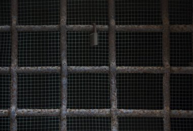 Kilit eski pencerenin demir parmaklıklarında asılı. Tam çerçeve çubuğu 