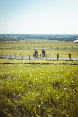 Hollanda, Drenthe 'de VAM-Berg' de bisiklet süren yaşlı bir çift. VAM-Berg boş zamanlarında yaratılan yapay bir tepe. 2020 'de güneşli bir gündü..