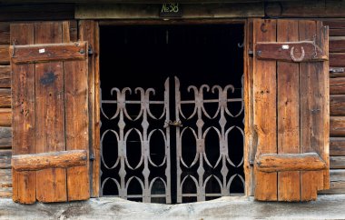 Ahşap kulübede kepenkleri olan pencere.