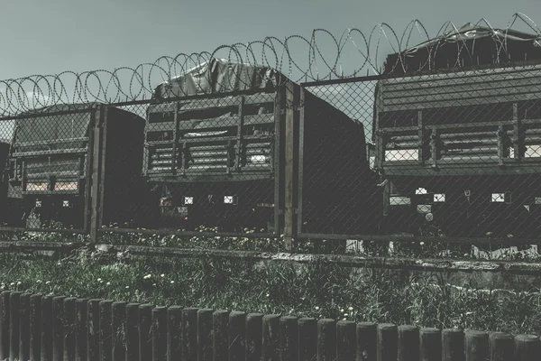 Militärlager, Militärfahrzeuge, hinter dem Zaun ein alter dunkler Hintergrund — Stockfoto