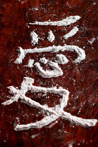 Jeroglífico japonés con harina, que significa amor, un fondo rústico viejo oscuro — Foto de Stock
