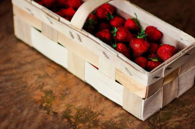 vintage tarzı bir karanlık eski rustik arka plan üzerinde bir sepet içinde çilek