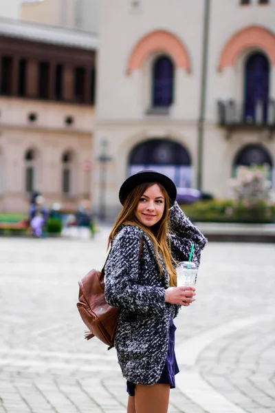 Jovem linda menina bonita andando ao longo da rua com bolsa e xícara de café . — Fotografia de Stock