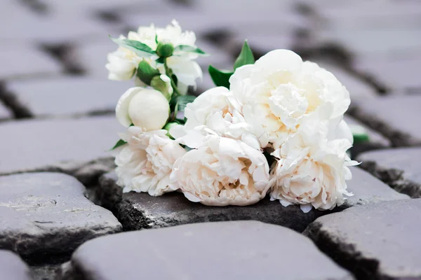 bouquet of peony white on asphalt and stone concept