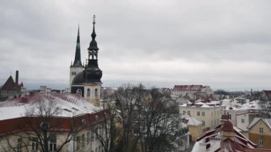 Kışın Tallinn 'in eski kasabası. Old Town 'dan karlı ve soğuk hava klibi. Güzel bir kış havası. Arka planda Aziz Olaf Kilisesi