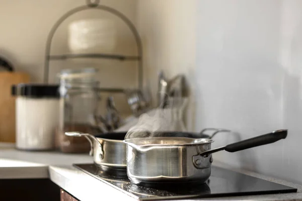 背景をぼかす 選択的フォーカス 台所の電気ストーブの上の鍋に蒸気で水を沸かす — ストック写真