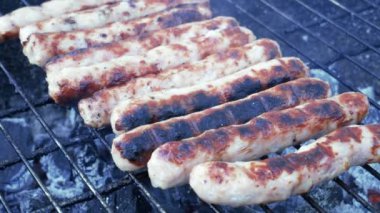 Izgaradaki tavuk sosislerinin en üst görüntüsü. Barbekü ızgarasında ızgara sosis. Bahar mevsiminde ilk açık hava barbekü partisi. 
