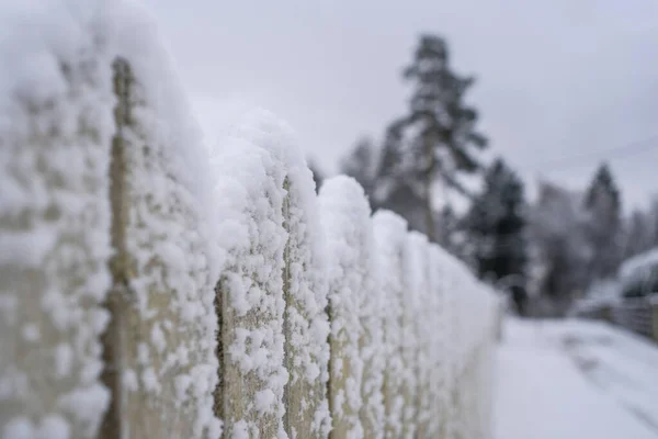Snow on a wooden fence after snowfall.