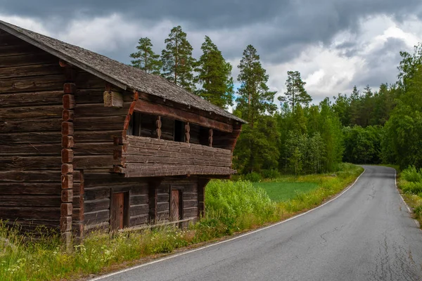 牧草地 道路の近くに古い小さな木造の家 背景には劇的な空が広がっています フィンランドのマック — ストック写真