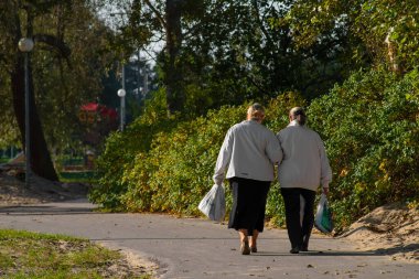 Pelguranna Parkı 'nda yavaşça yürüyen yaşlı kadınların arkasından bakın. Güneşli bir sonbahar sabahı. Tallinn, Estonya.