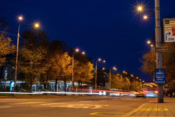 提灯に照らされた夜の道 夜のヴィルー広場の長い露出ショットは 車両のライトの動的効果を作成します エストニアのタリン — ストック写真