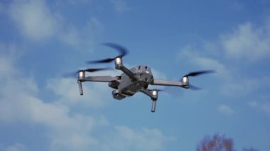 DJI Maviç 2 PRO güneşli bir bahar günü havada süzülüyor. Soğuk havada dron kullanmak.