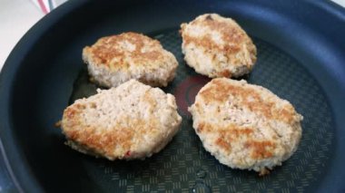 Ev mutfağında sağlıklı bir yemek hazırlama süreci. Kahverengi kabuklu sulu tavuk pirzolası, kızgın tavada cızırdıyor. Sağlıklı yeme kavramı