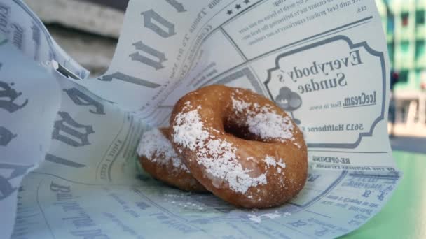 在室外咖啡馆的桌子上 用糖粉覆盖的甜甜圈做特写 — 图库视频影像