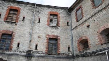 Hapishane duvarlarının dış görünüşü. Pencere önünde metal parmaklıklar olan Tallinn Estonya 'daki Patarei cezaevi kalesi