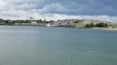 Tallinn, Estonya - 01 Ağustos 2021: Deniz kenarında Tallinn Kalesi 'nin bulunduğu Baltık deniz kıyısının güzel manzarası. Limandaki limanlarda gemiler. 