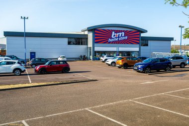 Norwich, UK- 17 Mayıs 2025: Norwich, İngiltere 'de güneşli bir günde kalabalık otoparkı olan İngiliz indirimli satış mağazası önü. Büyük bir depo tarzı alışveriş merkezi