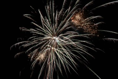 Altın Havai fişekler Parlayan Parçacıklar ve Işıldayan Işıklar ile Gece Gökyüzünde Patlıyor. Yeni Yıl Kutlama Festivali Arkaplanı için Muhteşem Piroteknik Görünümü