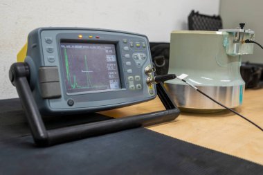 Ultrasonik test ekipmanı kalibrasyon düzeneği, dijital hata dedektörü ve masada bir referans bloğu. Tekerlek teftişi için kalibrasyon örneğine bağlı dalga biçimi ekranı gösteren NDT aracı