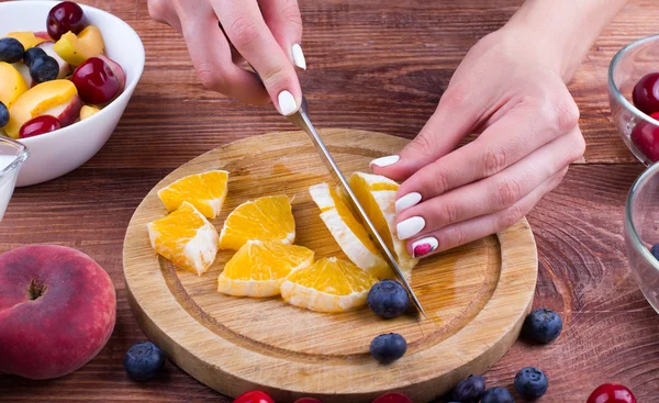 The person cooks fruit salad.