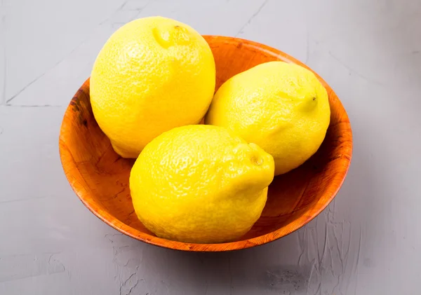 ahşap bir kapta limon 