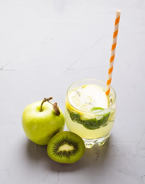 Dricka från en citron, en kiwi, äpplen, — Stockfoto