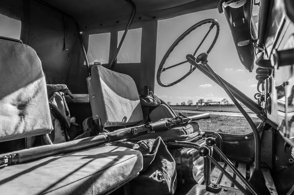 Interior preto e branco do jipe WW2 com rifle em todo o assento . — Fotografia de Stock