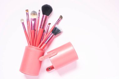 Pembe arka planda pembe makyaj fırçaları