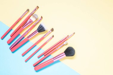 Pembe makyaj fırçaları pembe ve sarı arka planda