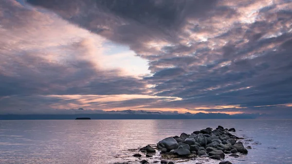 一个海水覆盖岩石的海湾 在夕阳西下的天空的映衬下 紫色色调的海景 — 图库照片