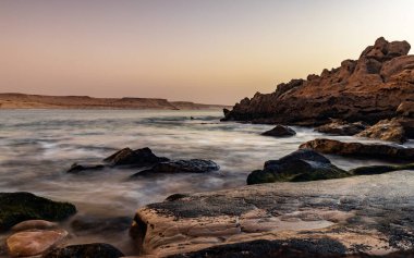 Atlantik Okyanusu, Fas 'ta kayalık kıyı şeridinde dalgaların üzerinde gün batımı.